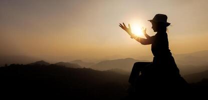 Silhouette von Person Frauen demonstrieren ihr religiös Glaube. Frauen Hand im Gebet, ausdrücken seine religiös Vertrauen im Gott durch Anbetung von Jesus christus.turned zu Gott im Gebet. foto