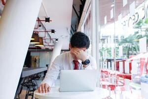 ein Geschäftsmann Wer ist im ein Zustand von Fehler weil seine Investitionen tun nicht Treffen seine Tore führen zu Stress und Kopfschmerzen. das Konzept von ein Kopfschmerzen fällig zu das falsch Geschäftsmann Investition. foto