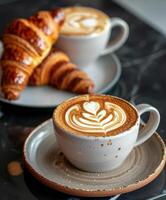 zwei Tassen von Kaffee und Croissants auf ein Tabelle foto