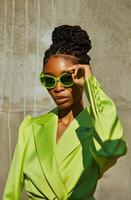 Frau im Grün passen und Sonnenbrille foto