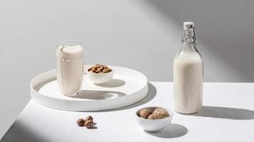 Milchflasche mit hohem Winkel und Glasschale Walnüsse foto