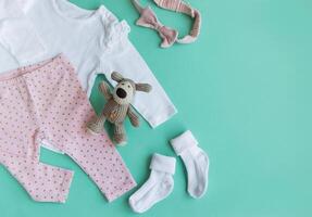 einstellen von Baby Bodys, Hose, Socken und gestrickt Spielzeug foto