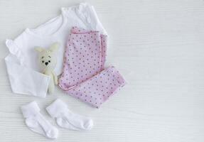 einstellen von Baby Bodys, Hose, Socken und gestrickt Spielzeug foto