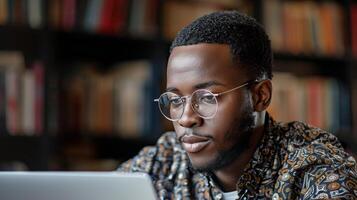 konzentriert jung Mann Arbeiten auf Laptop im Bibliothek foto