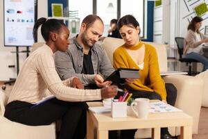 Mann Exekutive anweisen vielfältig Angestellte im Neu modern Unternehmen Büro Zimmer Vor Geschäft Treffen mit Partner Analysieren Berichte auf Tablette. vielfältig Kollegen Arbeiten zusammen beim Büro. foto