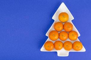 leuchtend orange reife saftige mandarinen in weißer platte, weihnachten und neujahr. foto