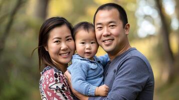 asiatisch Familie Porträt im ein Park. Mutter, Vater, und Baby Junge lächelnd. Konzept von Familie, Glück, Verbindung foto