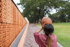 ein Frau Theaterstücke Basketball allein im ein Öffentlichkeit Abschnitt. foto