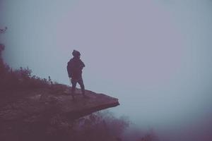 der mann reise steht auf einer klippe auf einem waldreichen berg. asien tropisch foto