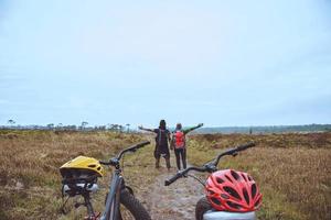 asiatische Liebhaberfrauen und -männer reisen fotografieren Natur. Reisen entspannen Fahrrad fahren Wildnis in der Wildnis.auf der Linie stehen. auf der Wiese im Wald. Thailand foto