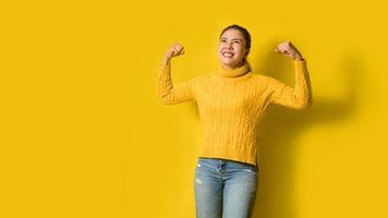 Porträt von schönen Mädchen, die glücklich lächeln und gelbes Stehset im Studio tragen. Frauen, die Stärke zeigen. gute Gesundheit foto