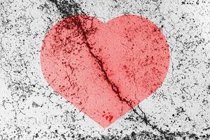 rot Herz auf ein geknackt Textur. das Konzept von gebrochen Herz und das Ende von Liebe. foto