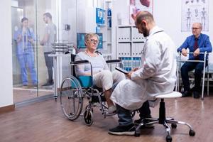 Frau mit Parkinson sitzt im Rollstuhl foto