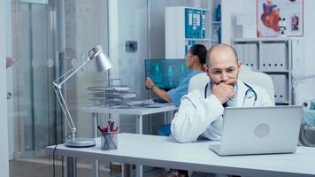 Mann Arzt tippt auf Laptop im modernen Büro foto