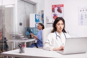 junger Therapeut mit Laptop in der Klinik foto