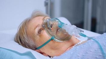Seniorin atmet langsam mit Sauerstoffmaske foto