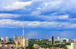 Fernsehturm und Wohngebiete von Kiew am Mittag vor dem Hintergrund eines stürmisch blauen Sommerhimmels. foto