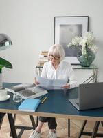 Senior schöne graue Haare Frau in weißer Bluse glücklich im Büro. Arbeit, Senioren, Probleme, Erfolg, Lösung finden, Konzept erleben foto