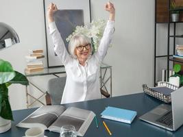 Senior schöne graue Haare Frau in weißer Bluse glücklich im Büro. Arbeit, Senioren, Probleme, Erfolg, Lösung finden, Konzept erleben foto