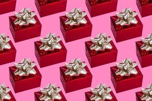 Boxtag. Weihnachtskomposition. rotes Geschenk mit goldener Schleife auf rosa Hintergrund. Muster.