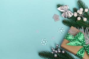 Frohe Weihnachten und ein glückliches Neues Jahr. Flaches Geschenk mit grünem Tupfenband und Ornamenten auf blauem Hintergrund. urlaubskarte kopierraum hautnah foto