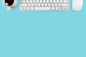 Arbeitsplatz-Schreibtisch mit Computer und Kaffee auf blauem Pastellhintergrund