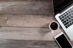 Schreibtisch aus Holz mit Computer und Smartphone mit Kaffeetasse foto