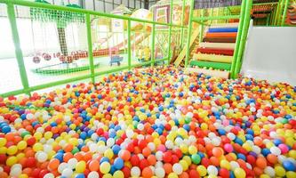 Kinderspielplatz drinnen im Vergnügungspark mit bunten Bällen zum Spielen - im schönen Kinderspielball aus farbigem Kunststoff des Spielzimmers foto