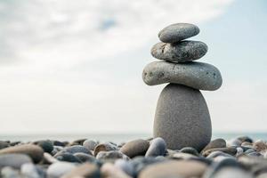 Steinpyramide am Kieselstrand als Symbol für Stabilität, Zen, Harmonie, Gleichgewicht. Konzept der Freiheit Entspannung foto