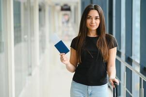 ziemlich Frau warten zum ihr Flug beim Flughafen foto