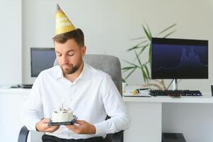 jung Geschäftsmann feiern Geburtstag allein im Büro foto