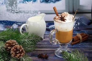 Heißer Kaffee Latte mit Zimtstangen, mit Zimt bestreut. Weihnachtsschmuck, Zweige eines Weihnachtsbaums. Urlaubskonzept neues Jahr. foto