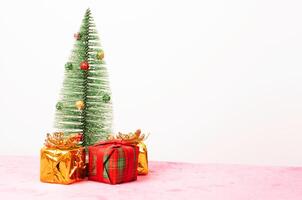 Weihnachtsbaum und Goldgeschenkbox für Weihnachtsfeiertagshintergründe foto