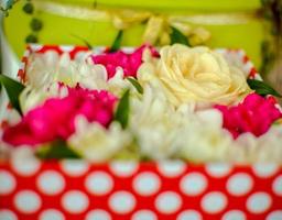 schöner Strauß gemischter Blumen aus Chrysanthemen, Nelken und Rosen in roter Box foto