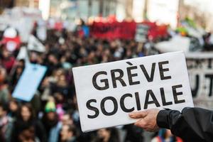 Montreal, Kanada 2. April 2015 - jemand hält einen Seufzer und sagt Greve Sociale mit verschwommenen Demonstranten im Hintergrund. foto