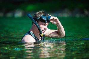 junger Erwachsener beim Schnorcheln in einem Fluss foto