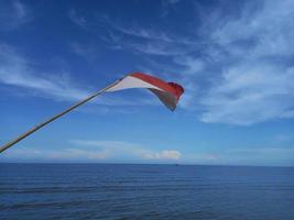 Flagge von Indonesien weht im Wind am Strand namens Sejarah, Sumatra foto