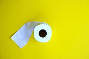 Toilettenpapier isoliert auf gelbem Hintergrund und Gesundheitskonzept foto