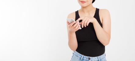 Frau SMS. Closeup junge glückliche schöne asiatische Japanerin. Mädchen, das Handy lokalisiert auf weißem Hintergrund betrachtet. positiver Gesichtsausdruck menschliche Emotionen. Platz kopieren. foto