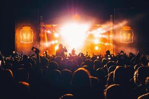Silhouetten von ein Menge von Menschen Fans beim ein Leben Konzert foto