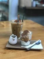 Milchkaffee und Eis in einem Glas auf einem Holztisch foto