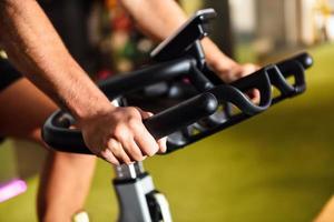 Hände eines Mannes, der in einem Fitnessstudio trainiert, das Cyclo Indoor macht. foto