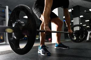 Nahaufnahme von Gewichtheben Training im Fitnessstudio mit Langhantel. foto