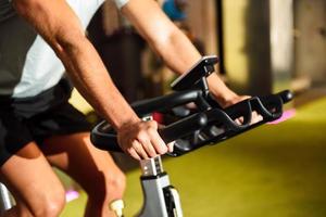 Hände eines Mannes, der in einem Fitnessstudio trainiert, das Cyclo Indoor macht. foto