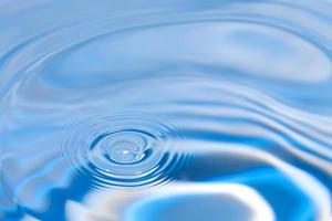 blaue Wasserwellenlinie Spritzmusteroberfläche und transparentes Wasser auf Blau. foto