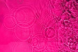 abstraktes ruhiges plätscherndes Wasser der Regentropfenbeschaffenheit in der rosa Farbe. ein Hintergrundmuster des klaren flüssigen Wassers für kreatives Design. foto