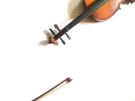 eine Geige und ein Bogen, isoliert auf weiss mit Kopienraum. ein klassisches Musikinstrumental, das mit Swiped gespielt wird und normalerweise in klassischen Musikshows aufgeführt wird. foto
