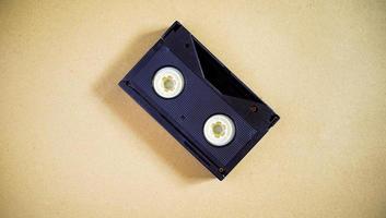 eine alte Audiokassette, die in der Vergangenheit beliebt war. eine schwarze Kassette auf einem beigen Schreibtisch. ein gepflegtes altes Zeug. foto