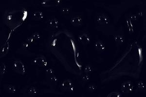 Wassertropfen auf schwarzem Hintergrund. abstrakte Tauwassertröpfchen auf einem Fensterglas für einen Foto-Overlay-Effekt oder einen frischen Effekt auf ein Getränkemodell. Makroaufnahme des detaillierten Regentropfens. foto