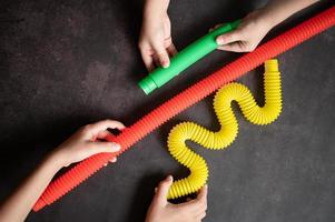 pop tube poptube kind kinder spielzeug antistress hände halten spielen foto